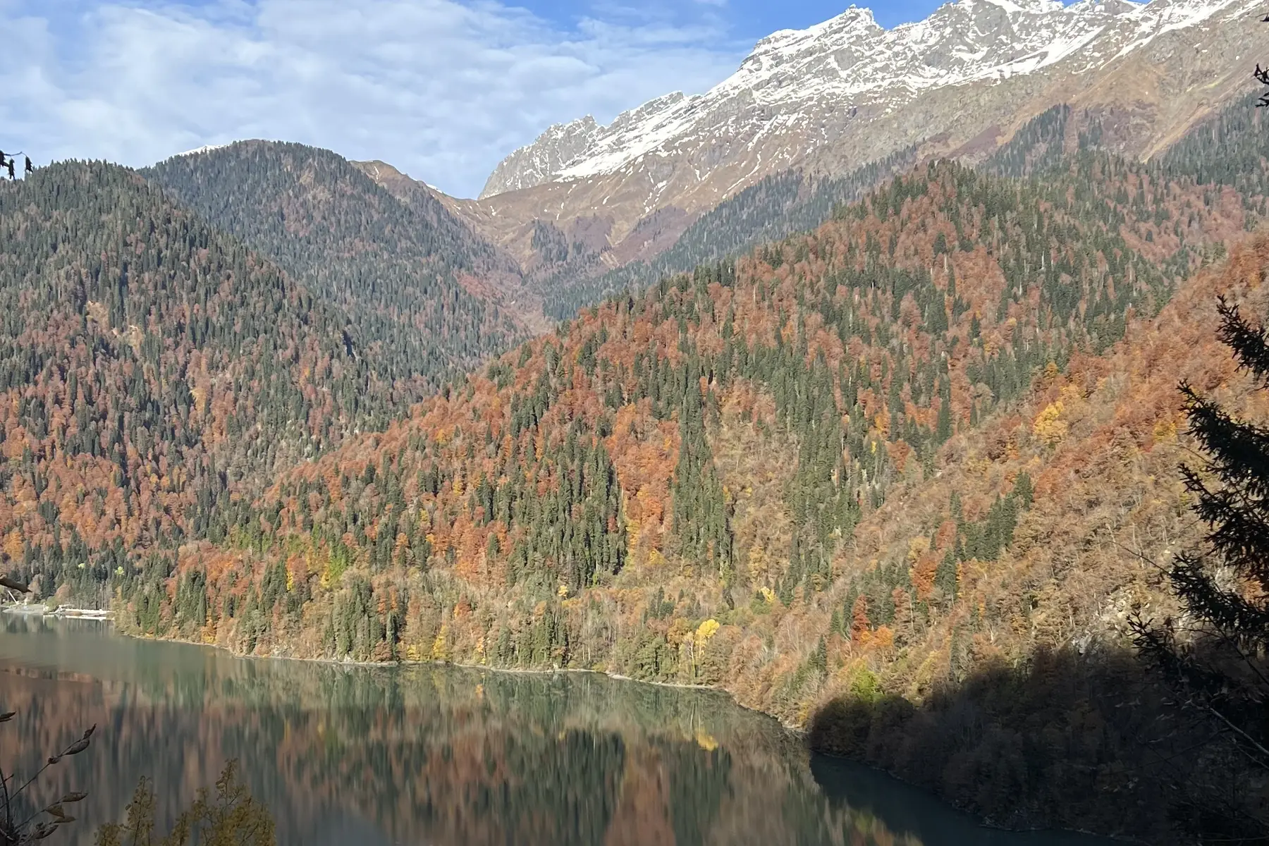 Озеро Рица осенью: тёмная вода и горы в отражении